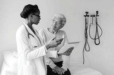 Picture of african femal doctor talking with elderly patient