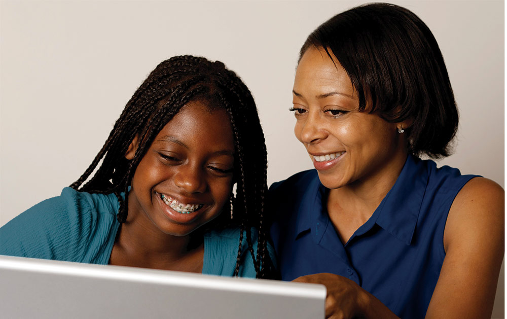 Image of mom and daughter looking at computer talking about how to spot a troubled teen